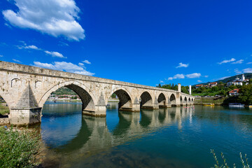 Fototapeta na wymiar Visegrad, Bosnia and Herzegovina - August 13, 2023: Famous bridge on the Drina in Visegrad, Bosnia and Herzegovina. Mehmed Pasa Sokolovic Bridge on Drina River