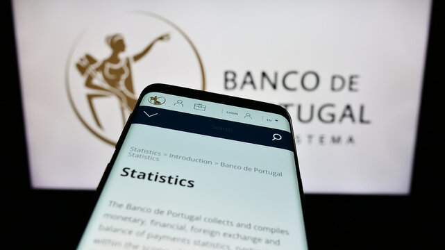 Stuttgart, Germany - 11-28-2023: Smartphone with web page of Portuguese central bank Banco de Portugal in front of logo. Focus on top-left of phone display.
