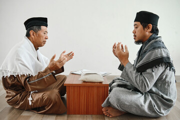 Muslim man praying together after giving and receiving donation or zakat at mosque. Islamic zakat...