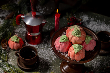 Homemade pink marshmallows in the shape of pumpkins surrounded by Christmas decorations.