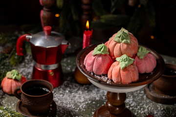 Homemade pink marshmallows in the shape of pumpkins surrounded by Christmas decorations.