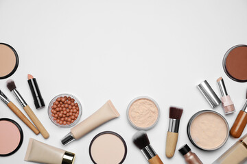 Face powders and other makeup products on white background, flat lay. Space for text