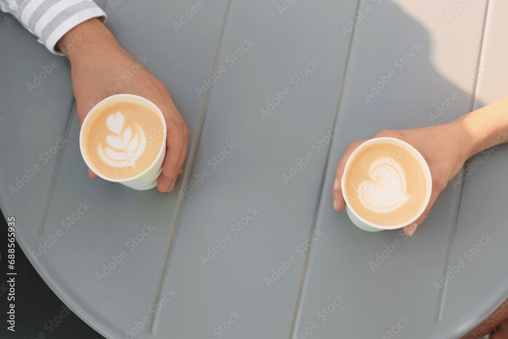 Sticker Coffee to go. Couple with paper cups at grey table, above view