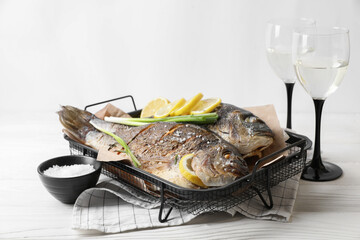 Seafood. Delicious baked fish served on white wooden table, space for text