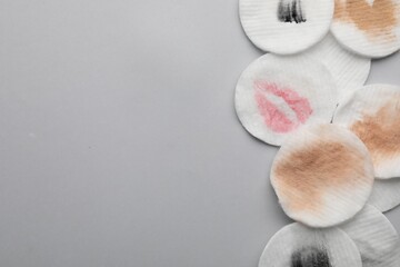 Dirty cotton pads after removing makeup on light grey background, flat lay. Space for text