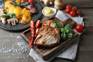Delicious grilled meat and vegetables served on wooden table