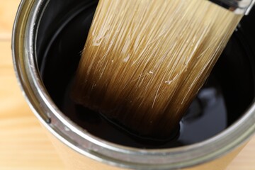 Dipping brush into can with varnish, closeup