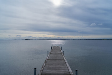 Seascape with waterfront and wooden pier at lake in the morning