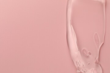 Sample of clear cosmetic gel on pink background, top view. Space for text