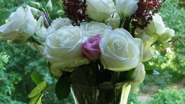 Bouquet of roses and eustoma in vase on blurred background