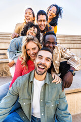Multi racial friends having fun together on city street - Group of young people smiling at camera outside - Vertical photo - obrazy, fototapety, plakaty