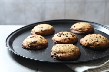 Tray with delicious chocolate chip cookies on table, closeup