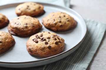 Plate with delicious chocolate chip cookies on table, closeup