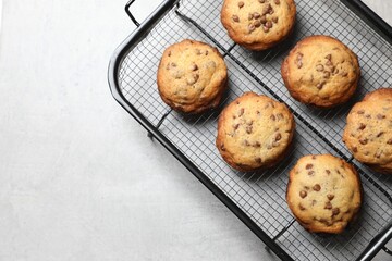 Cooling rack with delicious chocolate chip cookies on light gray table, top view. Space for text