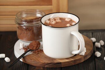 Cup of aromatic hot chocolate with marshmallows and cocoa powder served on table