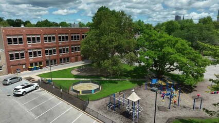 Brick school with elementary playground on beautiful day. Aerial shot of American education.