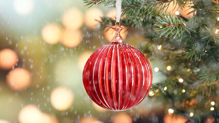 Christmas concept decorative red glass ball rotate on branch tree snow on background bokeh of side flickering light bulbs garlands for family holiday Happy New Year. Festival. Positive emotion. Noel