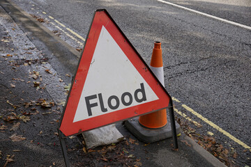 Flood warning sign on road after heavy rainfall. warning sign for motorists of ahead flooded road...