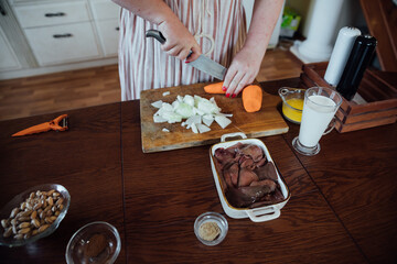 Female housewife in kitchen cooking food from vegetables