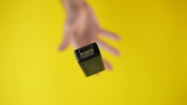 Hand throws USB stick in slow motion