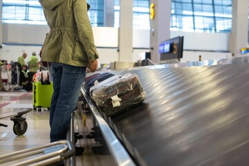 Luggage belt with suitcases being delivered to the passengers at the arrival terminal