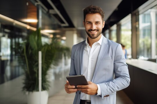 A positive smile in a male manager's jacket and a tablet in a modern office.