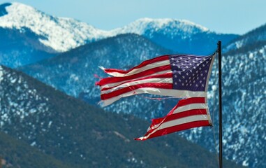 Ripped American flag at Cerro, New Mexico with the Sangre de Cristo mountains in the background
