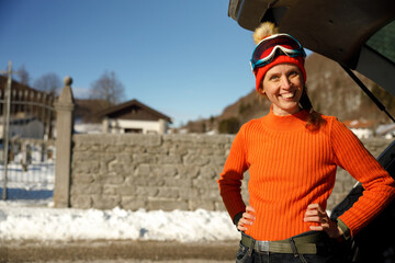 Obraz na płótnie Canvas Serene Adult Mature Caucasian Woman Smiling at Camera While Getting ready for a Ski Ride on her Winter Vacations