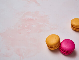 Colorful macaroon on the decorative table style and background, hand and plate style, up view.