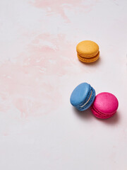 Colorful macaroon on the decorative table style and background, hand and plate style, up view.