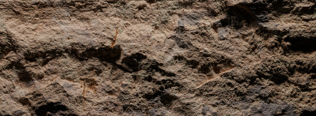 Brown stone texture, dark abstract background. Natural mineral rock close up details, empty backdrop with copy space for design