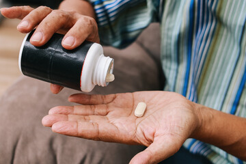Close up of elderly man hold vitamin pills. Painful old age, caring for health of senior citizen,...