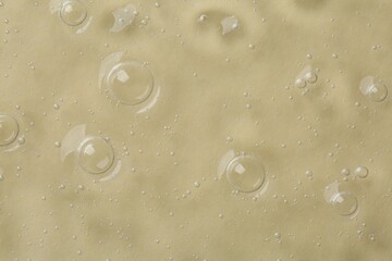 Cosmetic serum on beige background, top view