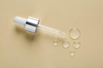 Pipette with samples of cosmetic serum on beige background, flat lay