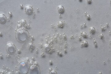 Clear cosmetic serum on white background, macro view