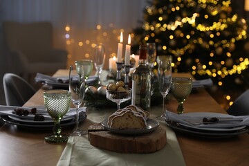 Christmas table setting with festive decor and dishware in room
