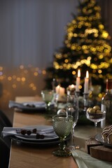 Christmas table setting with festive decor and dishware indoors