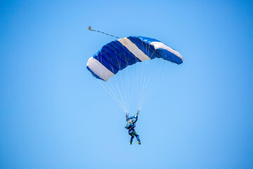 Skydiving. Flying parachutists against the background of the blue sky and mountains. Extreme sport...