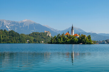 View of Lake Bled with St. Marys Church of Assumption on a small island on a sunny day. Lake with...