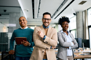 Happy multiracial business team in office looking at camera.