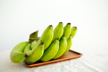 bunch of green bananas on a light background
