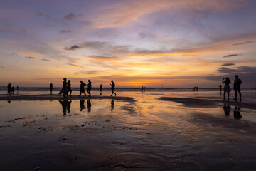 People on the beach in Seminyak at sunset, Bali Island, Indonesia