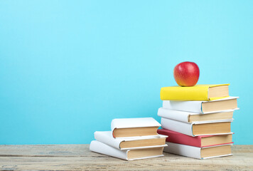 Books stacking. Books on wooden table and blue background. Back to school. Copy space for ad text.