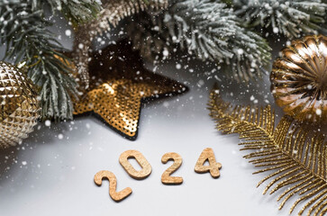 Banner. Happy New Year and Merry Christmas. Golden numbers 2024, snow, fir branches and Christmas tree toys on a white background. The flyer. Invitation.