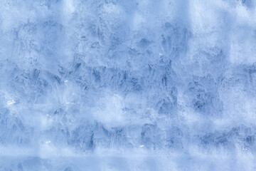 Texture of winter ice on a stone cliff. Blue natural ice background