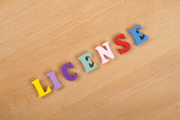 LICENSE word on wooden background composed from colorful abc alphabet block wooden letters, copy space for ad text. Learning english concept.