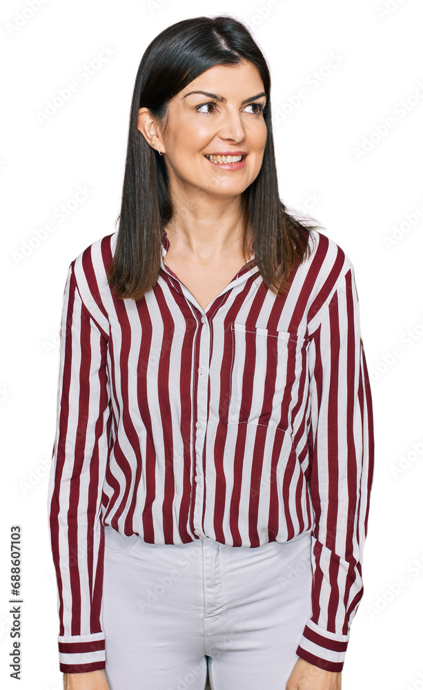 Poster beautiful brunette woman wearing striped shirt looking away to side with smile on face, natural expr