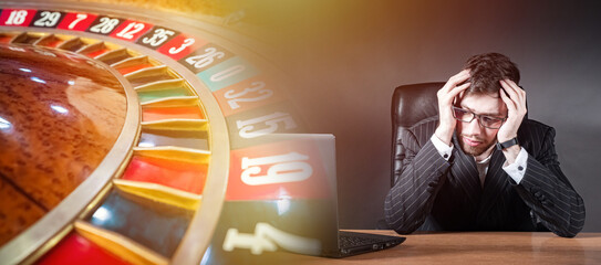 Man lost at casino. Roulette is game of chance. Guy is gamer sitting clutching head. Man went...
