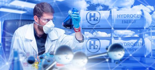 Hydrogen energy. Man scientist with test tube. Industrial experiments. Scientist develops fuel from hydrogen. Man laboratory assistant sits at desk. Hydrogen tanks. Technologist at fuel factory © Grispb