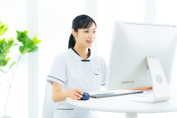 パソコンで作業する医療従事者の女性 - obrazy, fototapety, plakaty